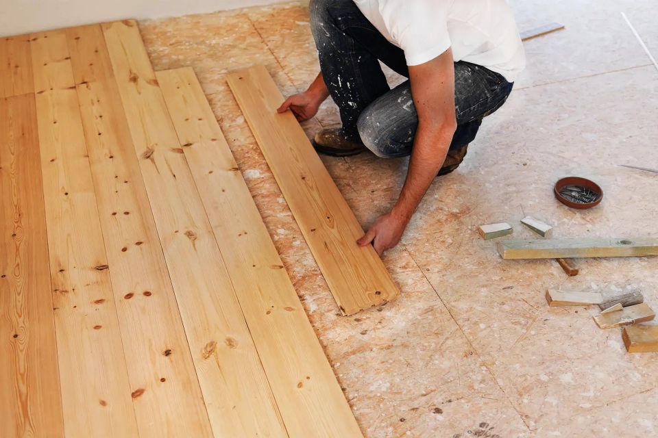 A man installing hardwood floor