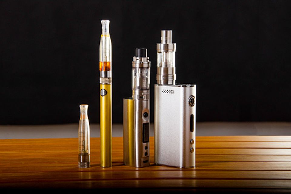 Vape pens and mods on wooden table