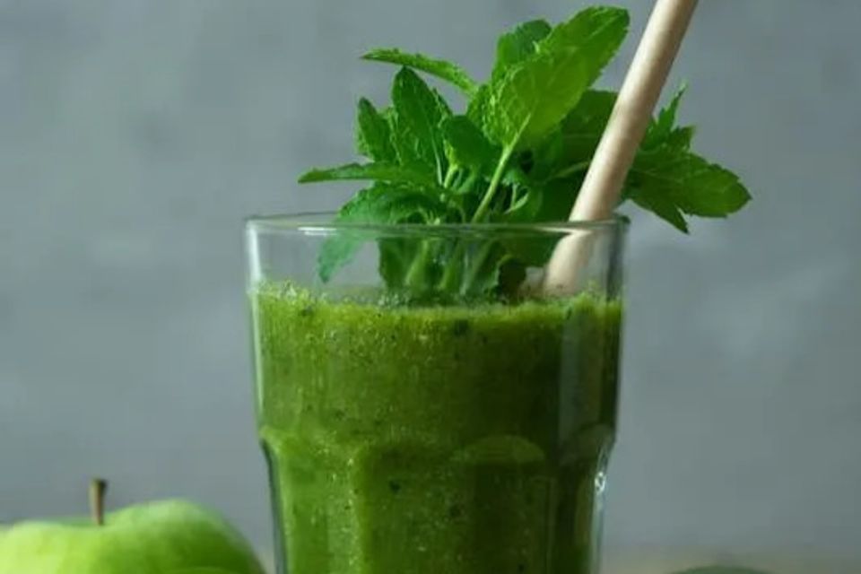 Green smoothie with mint fluffing out of it 