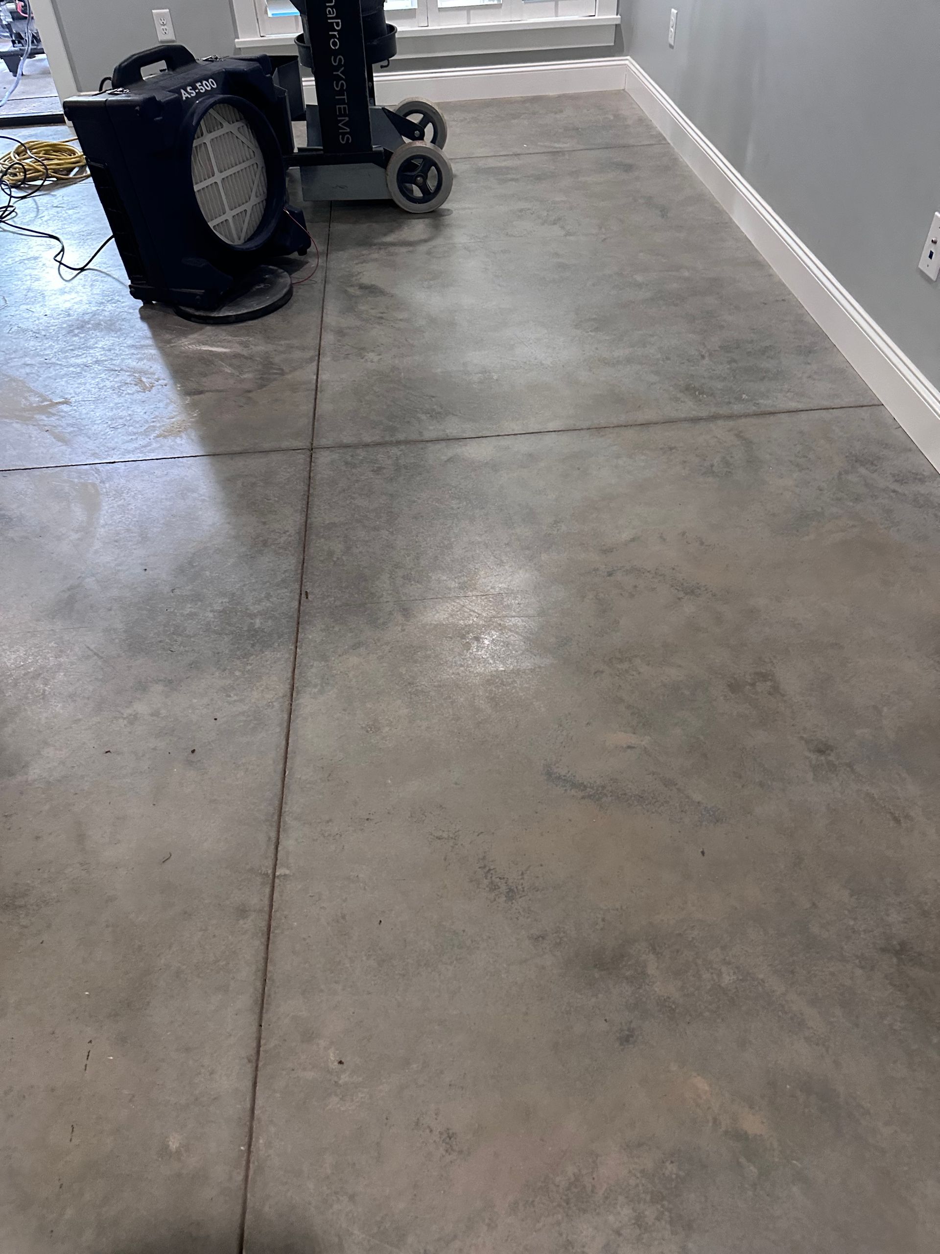 Finished decorative concrete basement floor with variegated gray and taupe tones