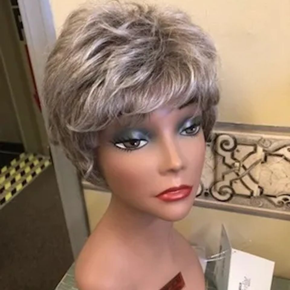 Short gray layered wig with soft volume and feathered texture displayed on a mannequin at Shears Wigs & Hairpieces Salon.