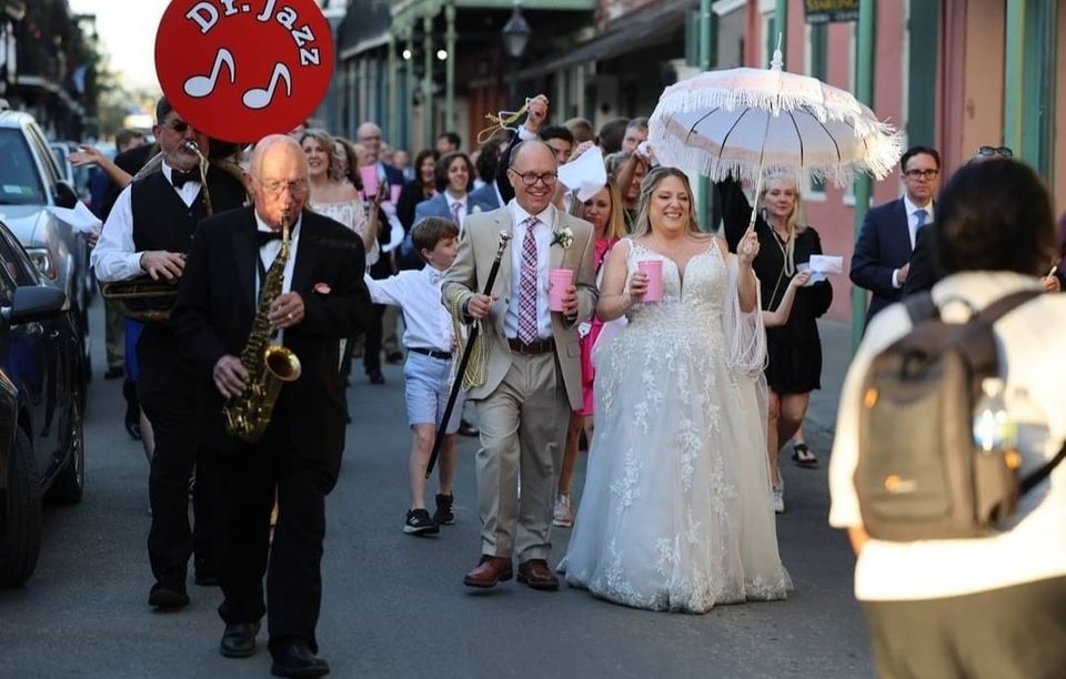 Wedding parade walking with a brass band through the French Quarter in New Orleans.