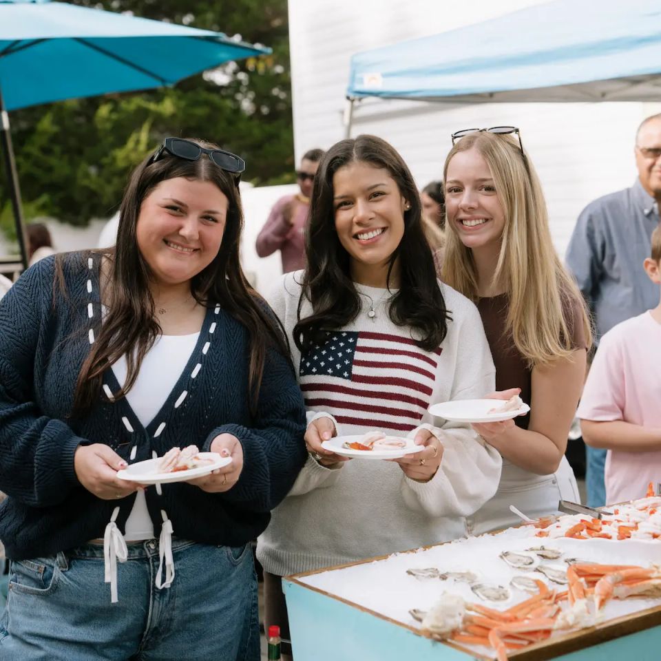 3 people having a fun time at a raw bar private event, catered by Shore2Shore Shucking of Long Island