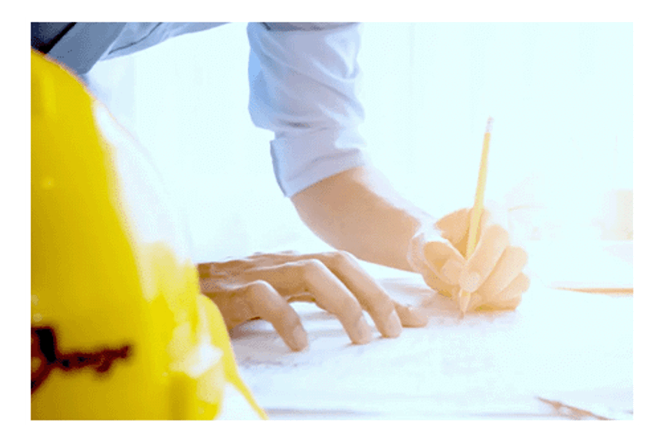 Worker drafting blueprints construction contractors