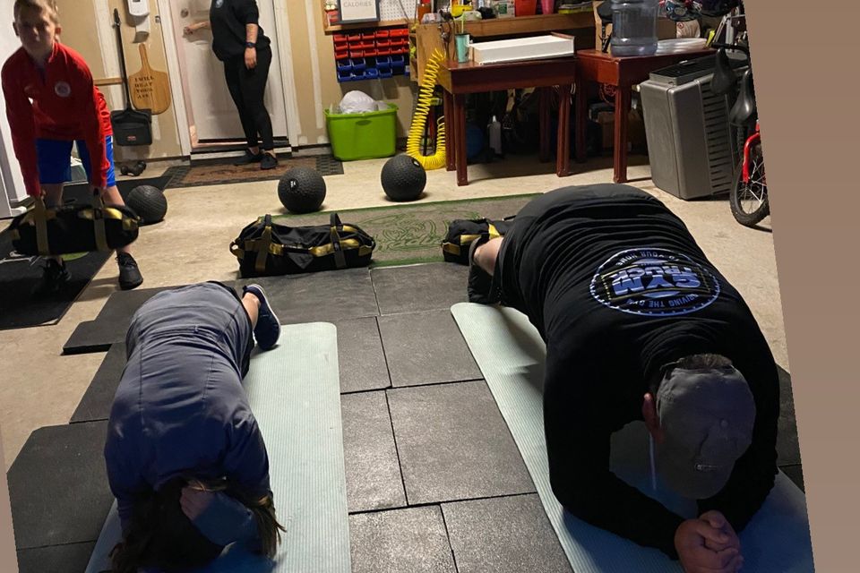 Image of 2 family members exercising as part of a small group exercise plan.