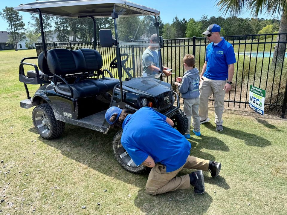 Two ngc technicians working on a golf cart