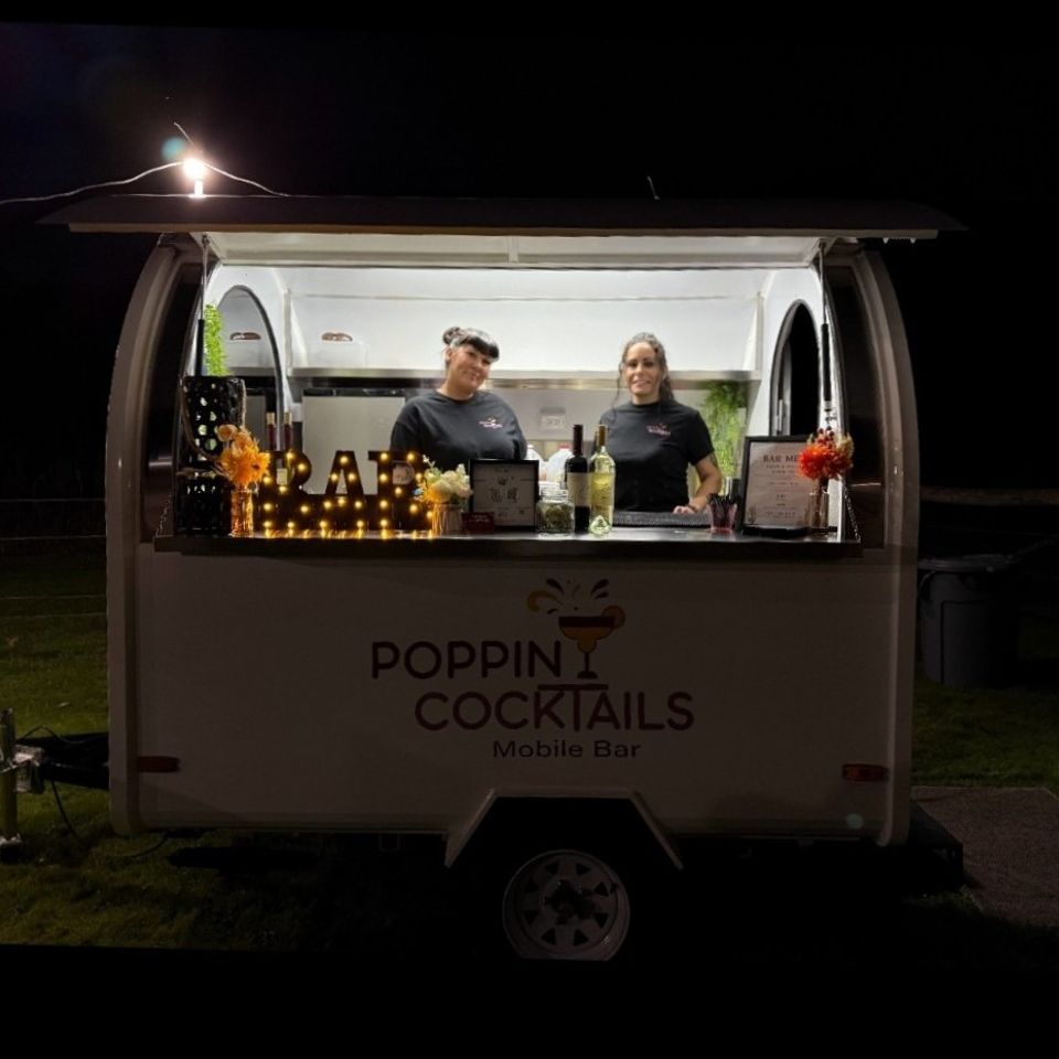 Bartending staff and owner inside the Poppin Cocktails trailer bar ready for service