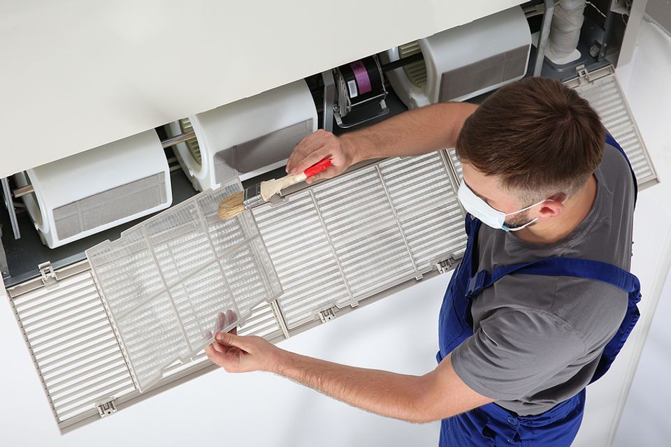Infinite Air Technician Cleaning Split Unit Air Vent in Raleigh