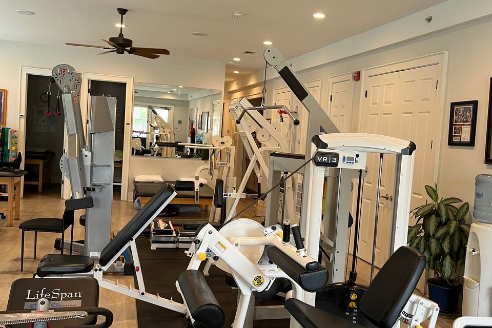 Leg press machine and hamstring curl machine along with shoulder rehabilitation equipment at Mid City Physical Therapy in New Orleans.