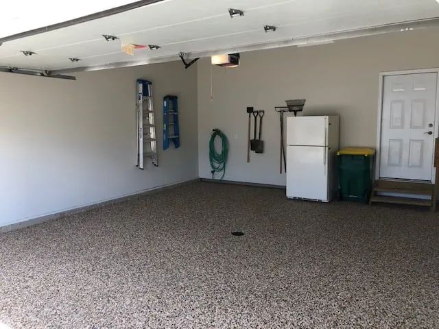 Residential garage featuring EverStone Epoxy Stone flooring with a natural stone finish.