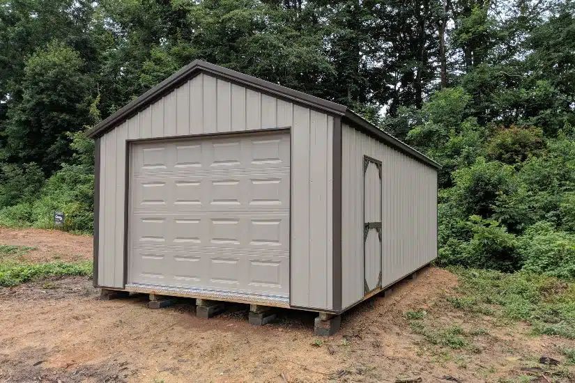 Tan cottage garage with overhead door and brown trim delivered to an East Tennessee lot