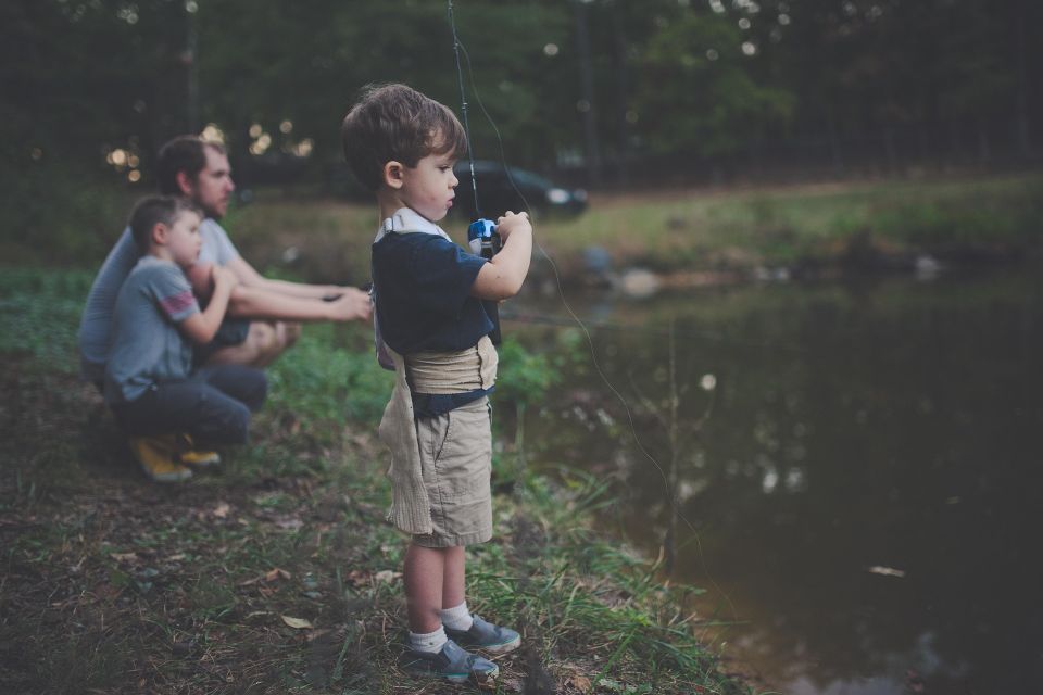 father spending time and bonding with two young sons and fishing
