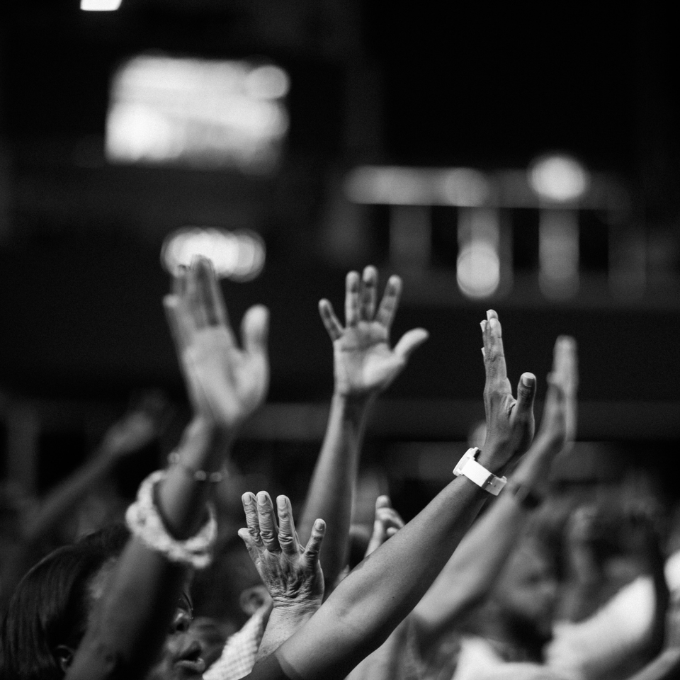Worshippers raising their hands in praise during a church service, expressing faith, reverence, and heartfelt worship.