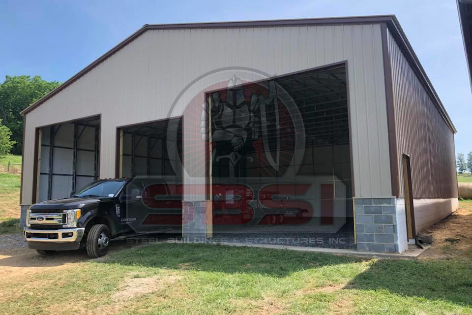 Tan steel building with open bays and block foundation with SBSI watermark representing steel buildings in Alabama