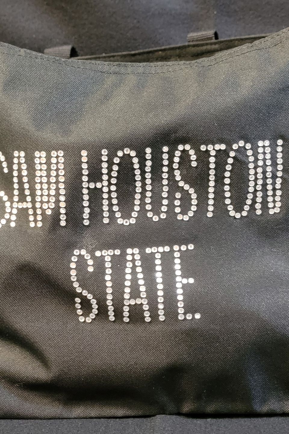 This is an example of a navy tote bag decorated with rhinestone bling that reads "Sam Houston State".