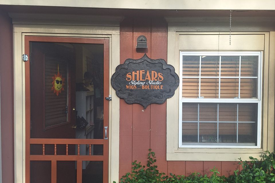 Entrance to Shears Wigs & Hairpieces Salon featuring the salon sign, front door, and window at its commercial suite location.