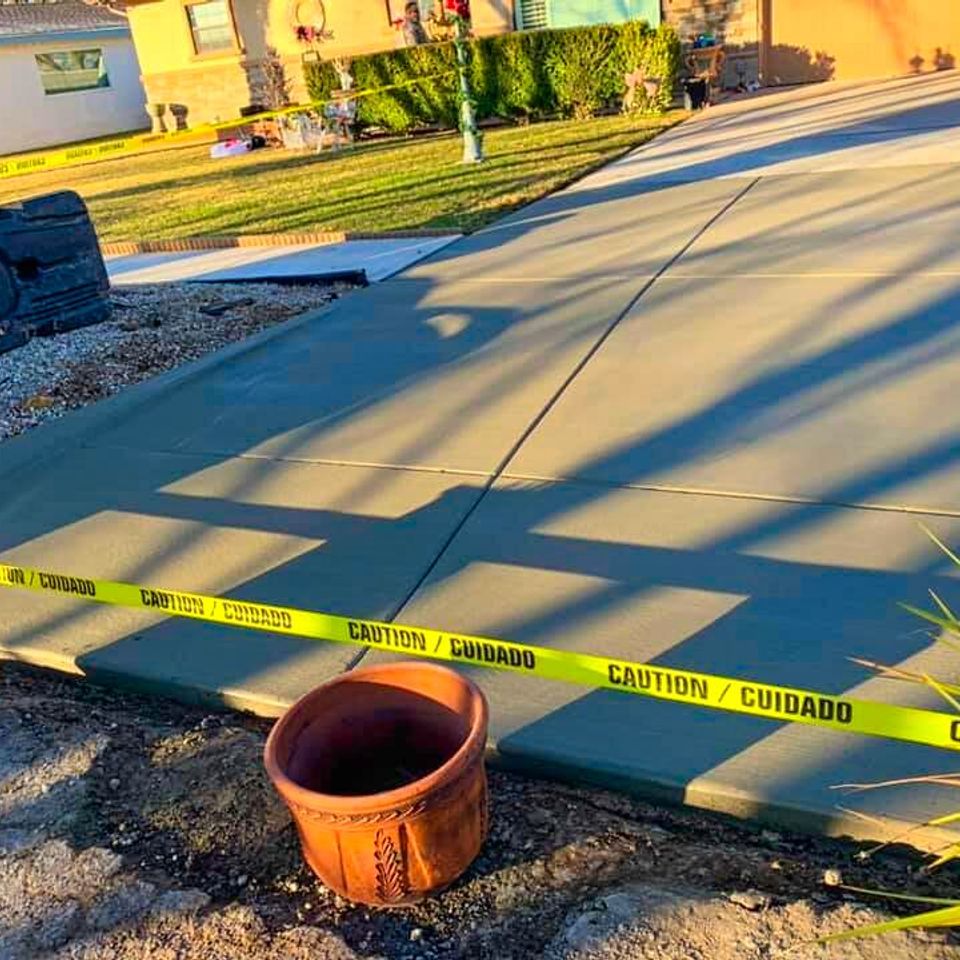 Newly poured cement patio curing behind safety caution tape during a professional residential installation project by Roseville Concrete Solutions.