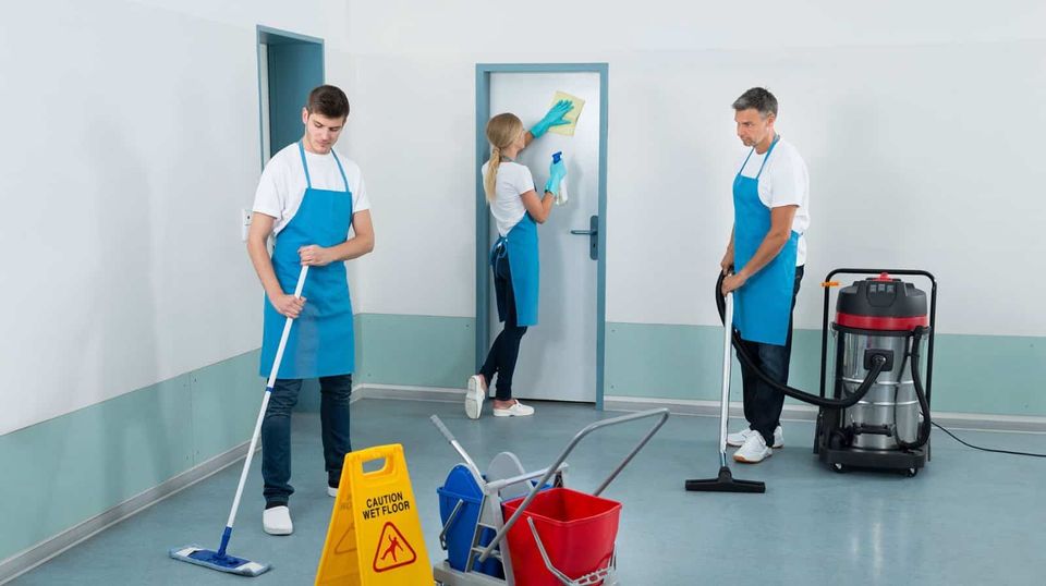 Professional janitors cleaning an apartment building hallway in Brooklyn.