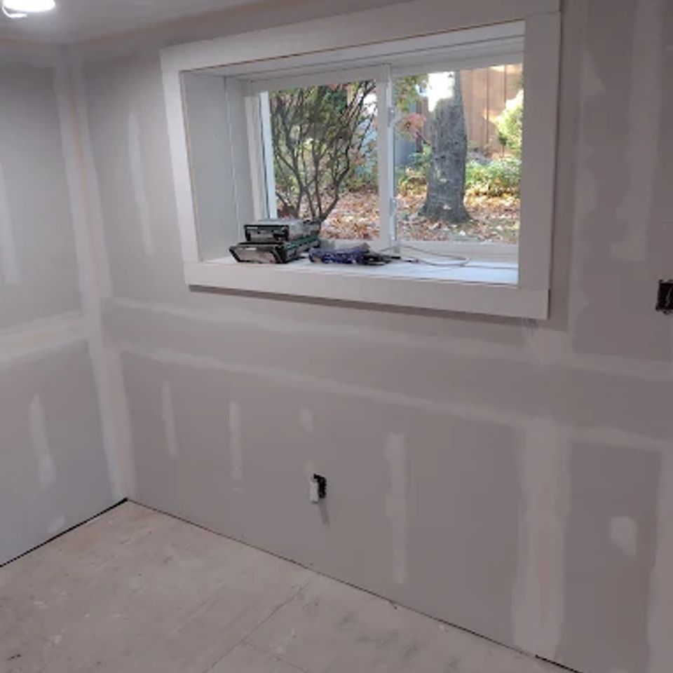 Basement drywall install with new window by general contractor in Suffolk County NY