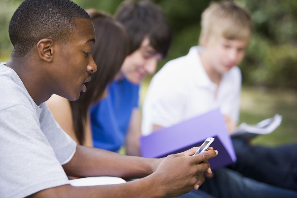Diverse high school teens students reading outside