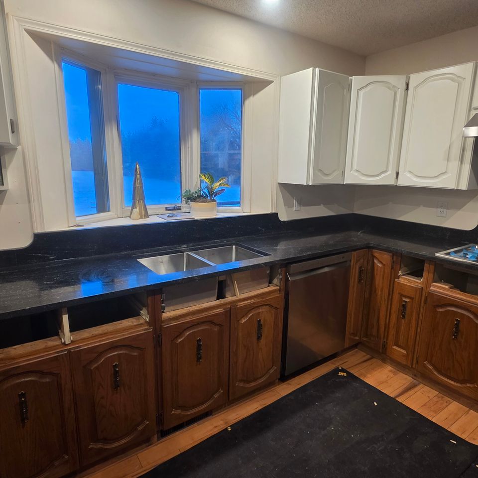 Black kitchen countertop with white cupboards