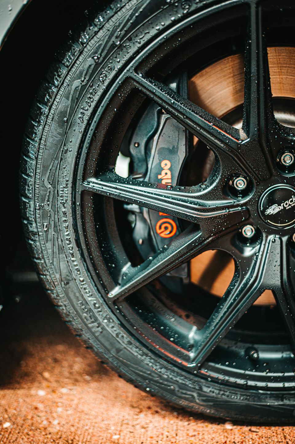 Image of brake calipers behind an installed wheel