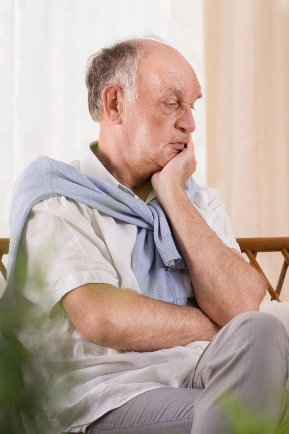 Thoughtful elegant elderly man resting his chin on his hand