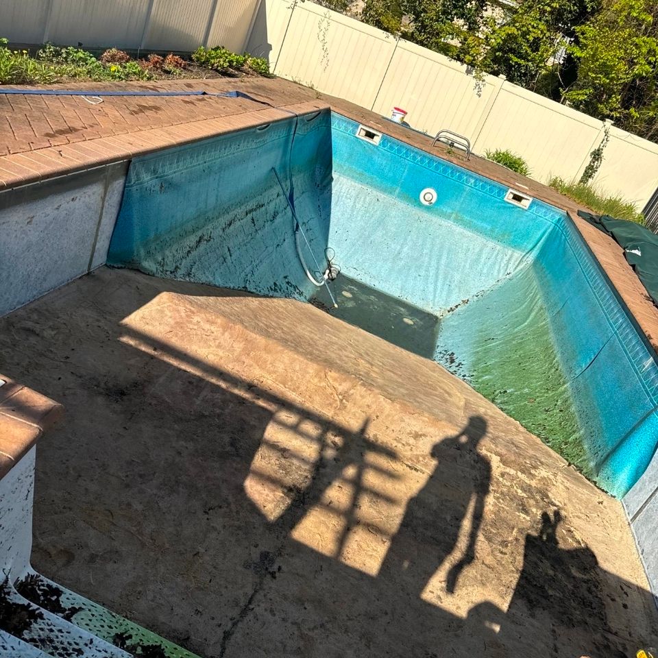 Drained inground pool with faded old liner before a liner replacement