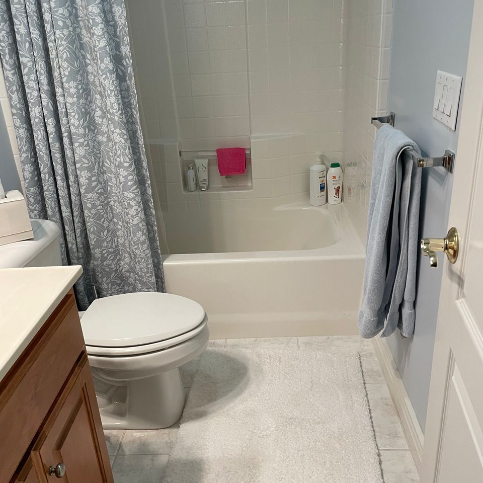 Clean bathroom with tub shower and tidy vanity after a house cleaning service in Virginia Beach VA
