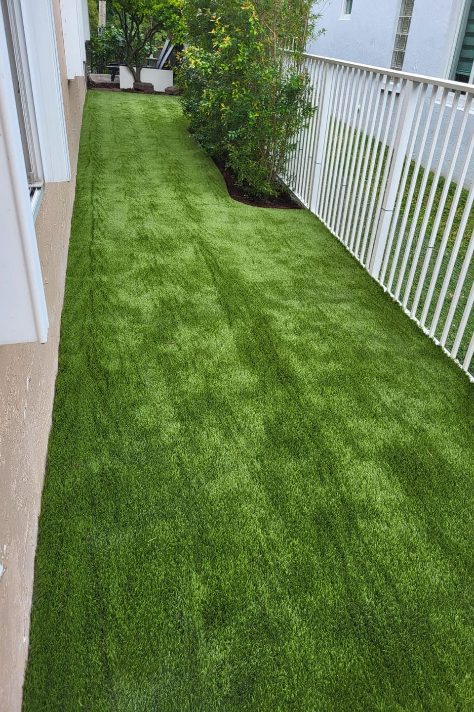 Fake grass completely installed near pink house