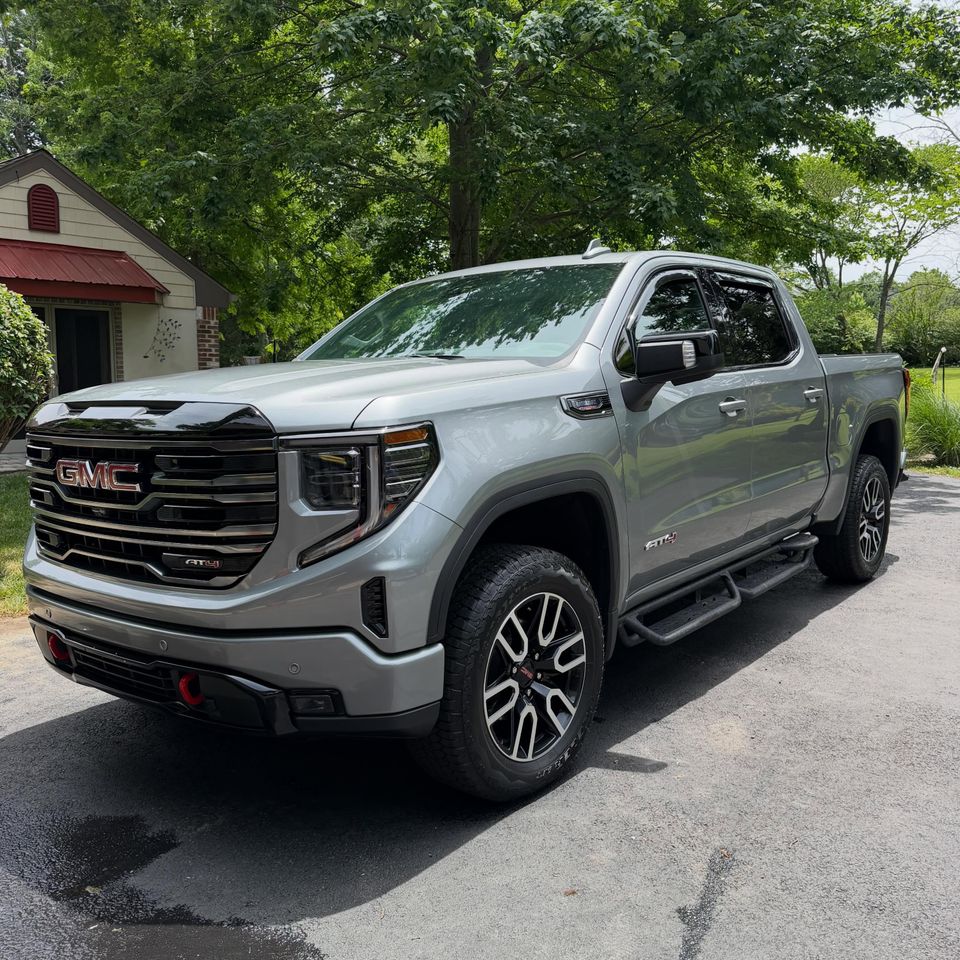 Gray GMC Sierra AT4 crew cab with glossy paint and dressed tires after exterior cleaning in Wilmington Delaware