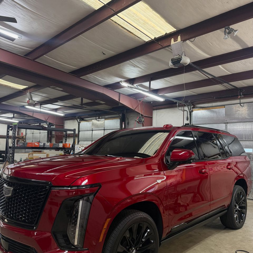 Red Cadillac Escalade with dark auto window tint on the side and rear windows in Moyock North Carolina