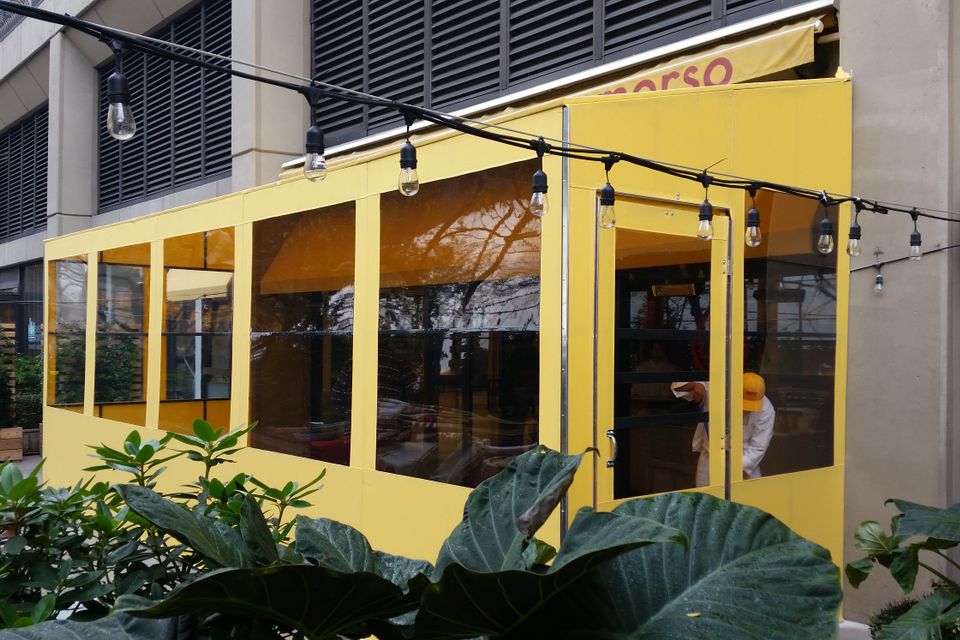 Yellow seasonal vestibule with clear vinyl panels enclosing a restaurant entrance Morso in New York City