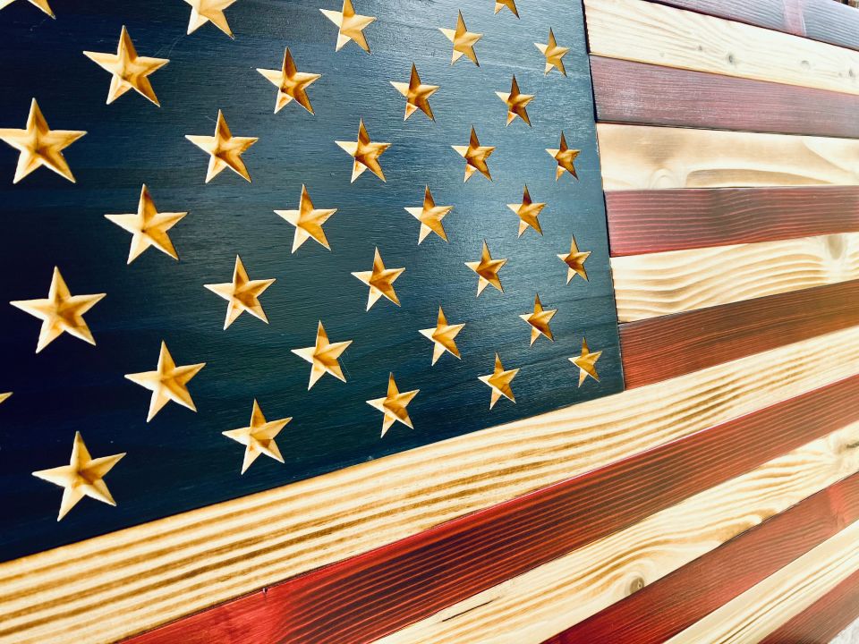 Handcrafted wooden American flag with carved stars and rustic stained stripes