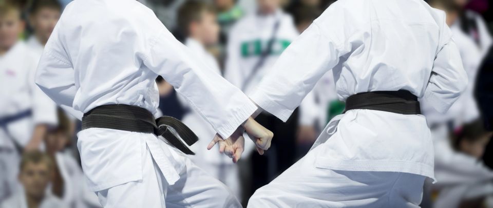 Karate students in a downblock position