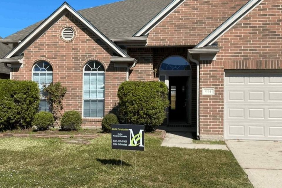 Freshly painted trim and soffit on a brick home exterior