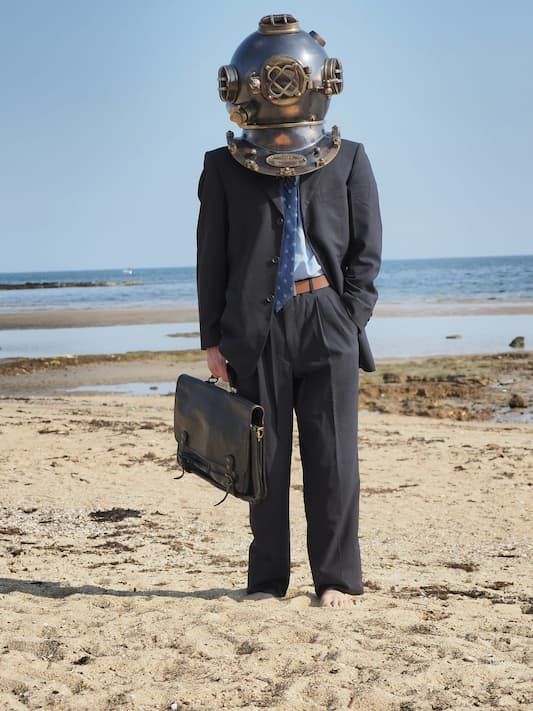 Person in business suit with briefcase with old timey diving helmet 