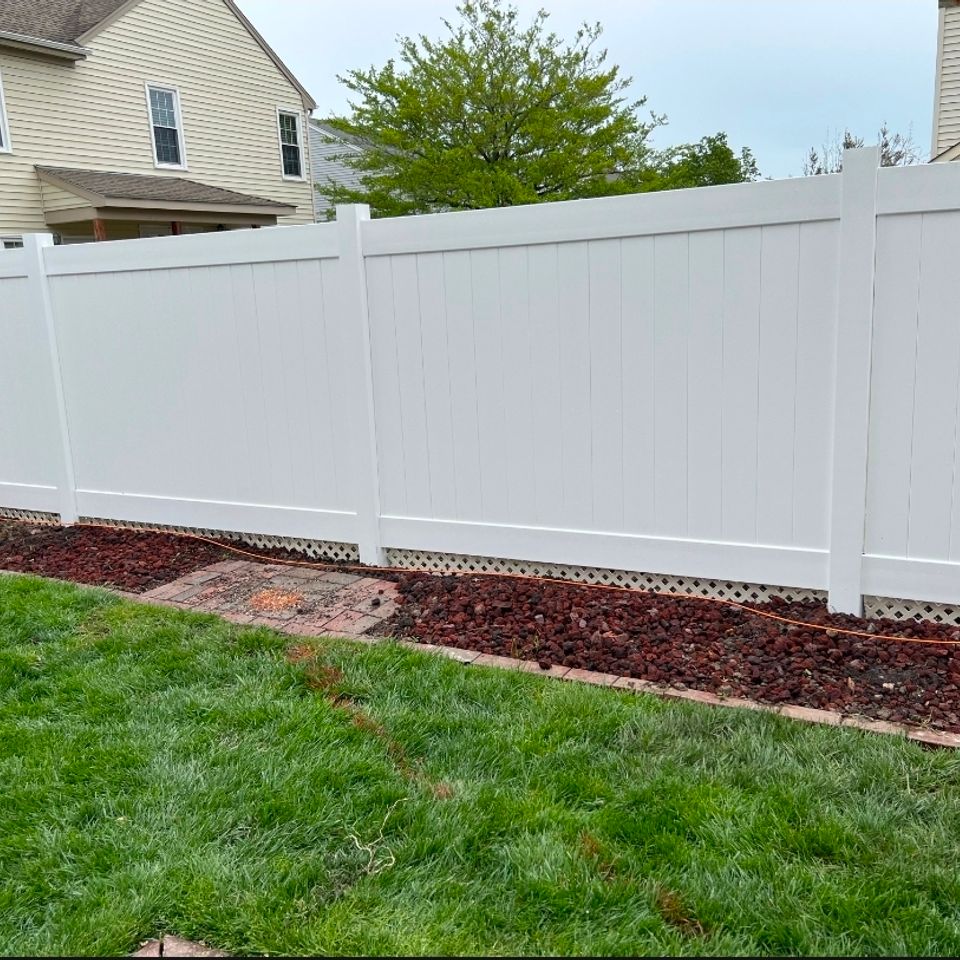 White vinyl privacy fence with lattice bottom installed along landscaped yard in Virginia Beach VA 