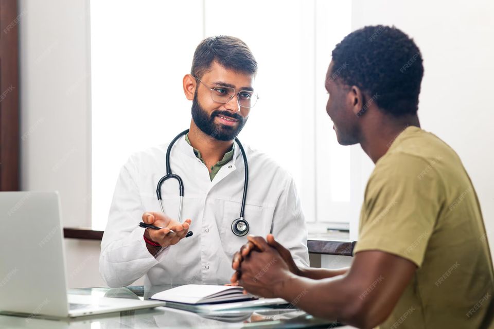 Physician consulting with and supporting a patient in a clinic