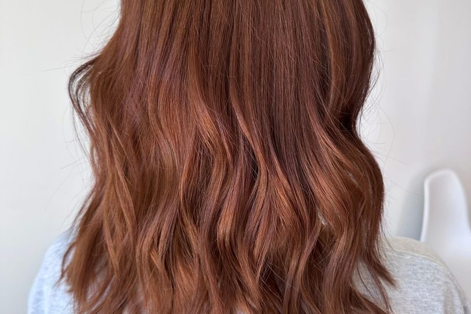 Medium length copper red wavy hair after vibrant color and styling in Columbiana AL