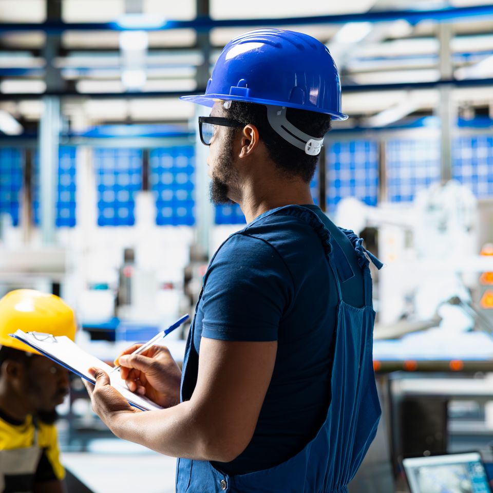 African american supervisor evaluates renewable energy metrics factory