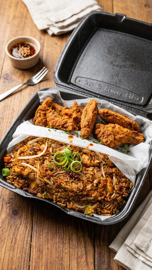 Korean‑style fried chicken wings with Wing Dash’s iconic St. Louis‑style fried rice in a takeout container from Wing Dash in Lewisville, Texas.