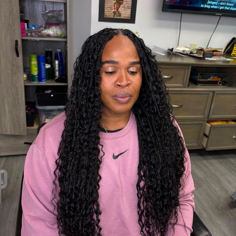 Client with long black goddess braids with wavy ends after hair braiding service in Los Angeles CA