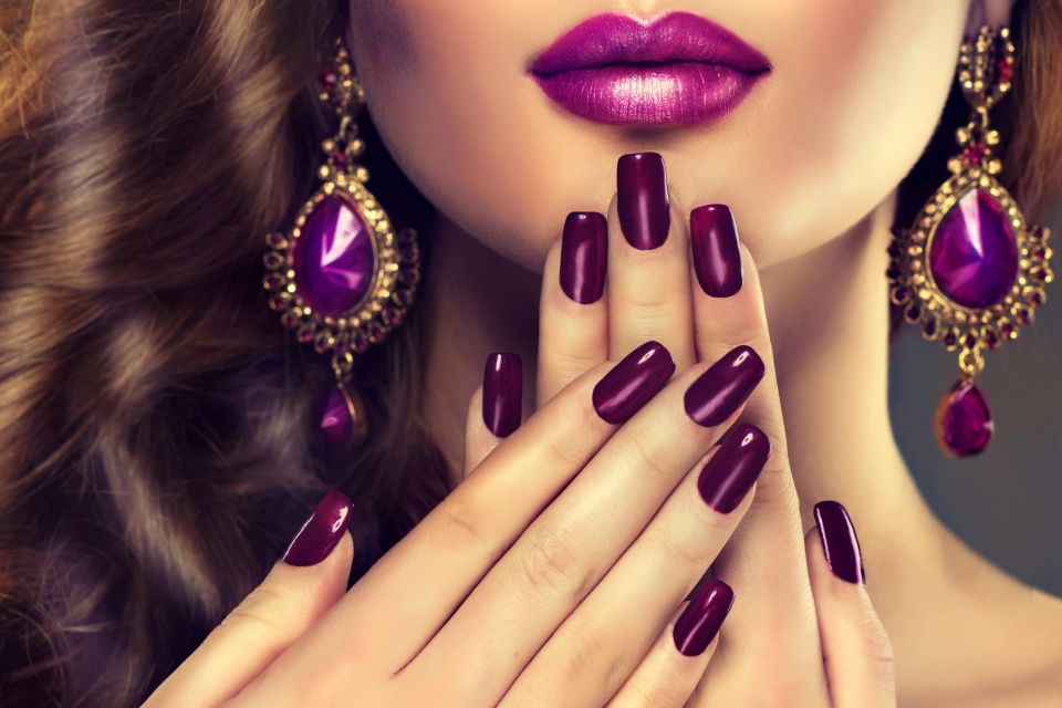 A woman with pink painted nails after her dip powder service