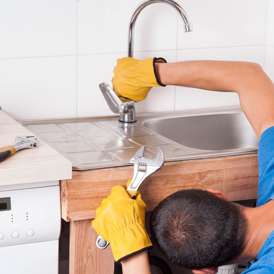 Plumber installs and connects the faucet on the sink
