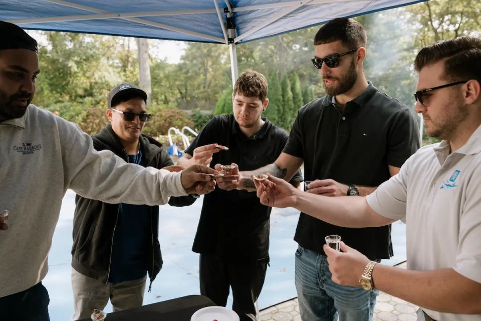 Group of guys enjoying a raw bar catering event, done by Shore2Shore Shucking of Long Island