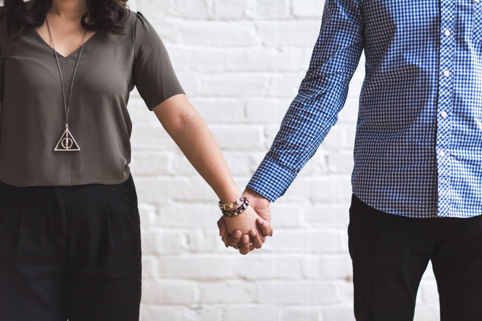 A married couple seeking guidance and support while holding hands during a Meridian Counseling session.