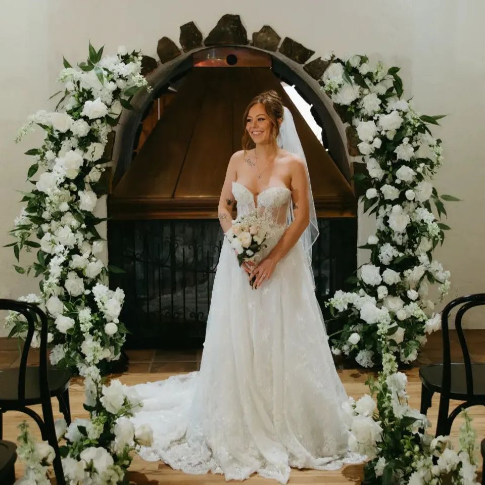 Bride standing with white and green floral arches available for rent in Denver, Colorado 