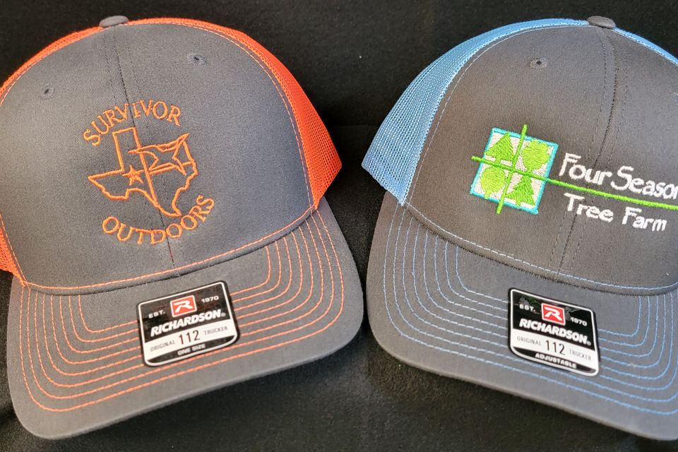 Embroidery example - company logo on orange and blue baseball caps