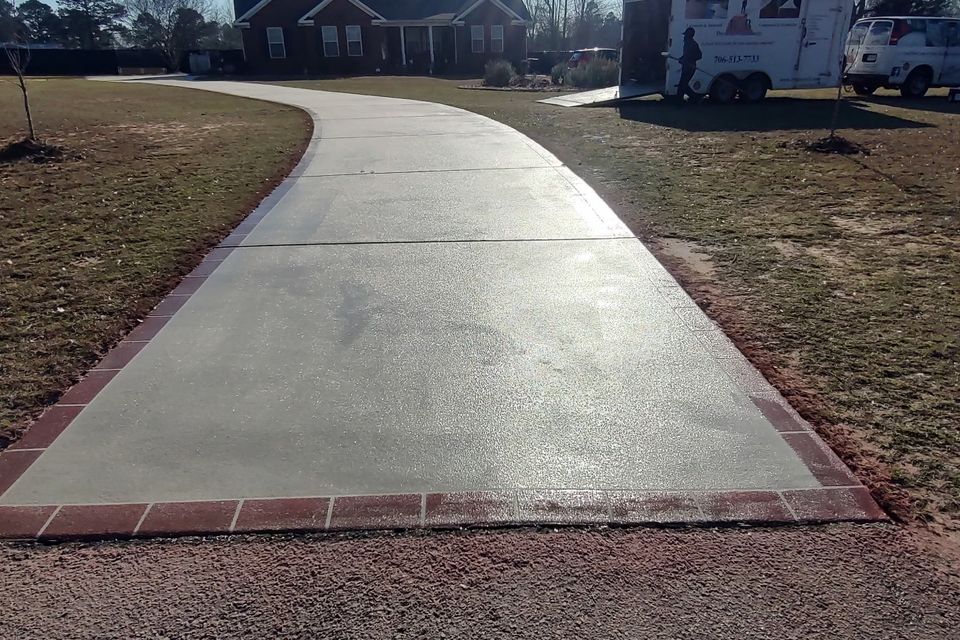 Refinished concrete driveway with a smooth, sealed surface, enhancing curb appeal and longevity.